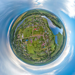 little planet 360-pano - above the council and a small park in the center of the village by a deep river, surrounded by green and yellow fields, under a sky with storm clouds on a summer day