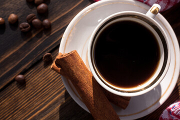 A cup of aromatic black coffee, a coffee grinder, a coffee maker, grains of different varieties on the table. Morning espresso or Americano coffee for breakfast in a beautiful cup. Still life. 