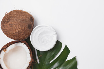 Natural coco cosmetic moisturizer cream on monstera palm leaf. SPA natural organic beauty product, skincare concept. Flat lay, top view