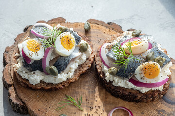 Danish open sandwich smorrebrod with herring, onion and eggs
