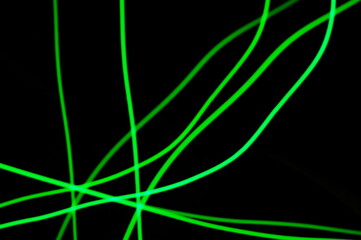 Green thin lines of light on black background. Laser irregular light beams. Luminous, bright threads of green color with high density.