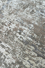 Background from a stylish carpet in neutral gray-beige tones with fading and artificial antiquity effect. Concept details of a fashionable interior, carpets. Abstract texture. Vertical