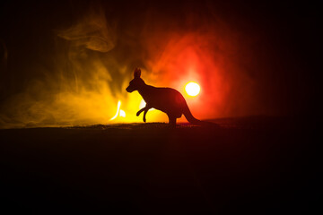 Kangaroo miniature standing at foggy night. Creative table decoration with colorful backlight with fog.