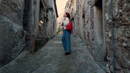 Giovane ragazza con jeans cammina per la città abbandonata