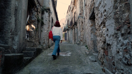 Giovane ragazza con jeans cammina per la città abbandonata