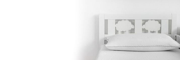 Minimalist interior design in white colors. Baby bed and white pillow on white background, abstract background