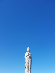 Blue sky and stone buddha statue