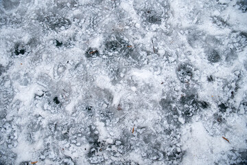 Snow that has started to melt, and footprints on it