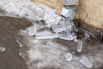 Pieces of ice from the drainpipe, on the ground