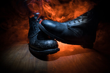 War concept. Old military shoe in a dark toned foggy background. Creative concept of conflict...
