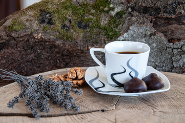 cup of espresso coffee, dry flowers and candies on wooden background