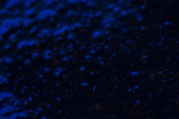 Abstract blue mysterious background. Rough texture in dark light. Oily, oily ooze with bubbles and lumps. Dark uneven background with reflected blue light. 3d illustration with gestural texture. © Adam Bialek