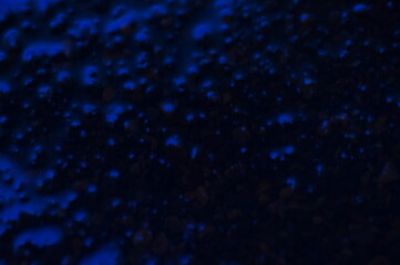 Abstract blue mysterious background. Rough texture in dark light. Oily, oily ooze with bubbles and lumps. Dark uneven background with reflected blue light. 3d illustration with gestural texture.
