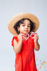 small African American girl in red summer clothes and a straw hat on a white background