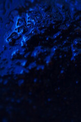 Abstract blue mysterious background. Rough texture in dark light. Oily, oily ooze with bubbles and lumps. Dark uneven background with reflected blue light. 3d illustration with gestural texture.