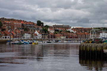 Fototapeta na wymiar The historic harbour at Whitby North Yorkshire showing small boats and the town in the distance