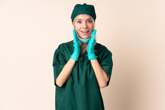 Surgeon woman in green uniform over isolated background with surprise facial expression