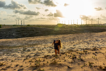 Jovem menina se diverte sozinha com poses em dunas