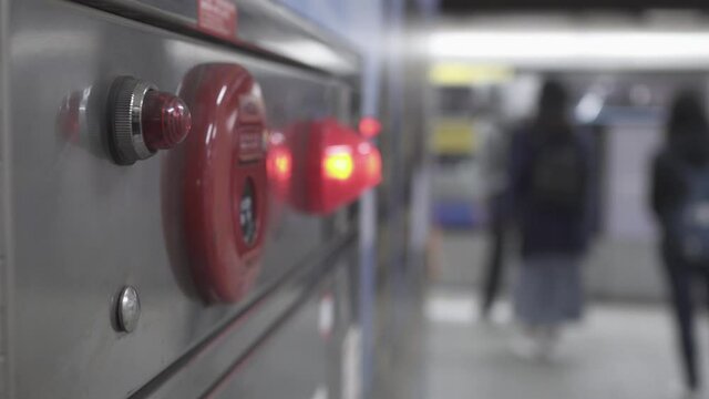 Close-up on fire fighting equipment in modern building. The lens shakes slightly. Many passengers walked into the train carriage. The background is blurred.