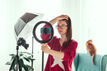 Young woman blogger getting ready to shoot video for vlog, backstage