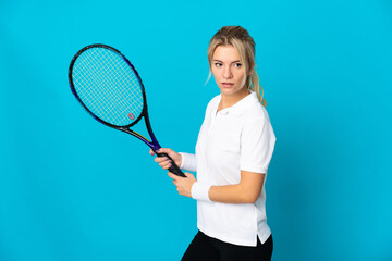 Young Russian woman isolated on blue background playing tennis