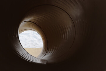 Yellow tunnel slide in the winter at a playground