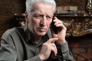 thoughtful senior man with smartphone