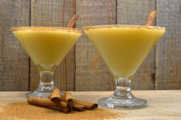 Boza and cinnamon sticks, traditional Turkish cuisine drinks, on wooden background