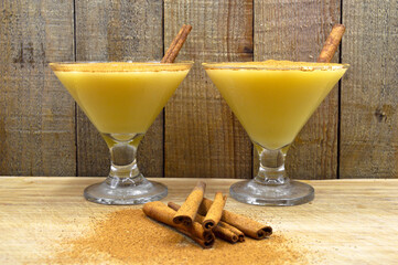 Boza and cinnamon sticks, traditional Turkish cuisine drinks, on wooden background
