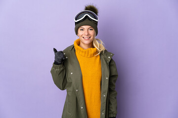 Skier Russian girl with snowboarding glasses isolated on purple background pointing to the side to present a product