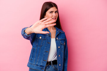 Young caucasian woman isolated on pink background rejecting someone showing a gesture of disgust.