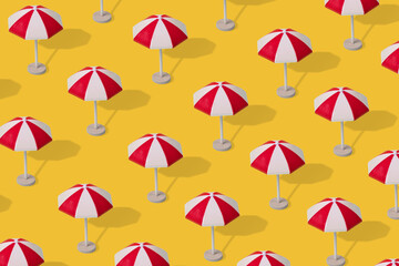 Fototapeta na wymiar Trendy summer pattern of colorful umbrellas on a illuminating yellow background.