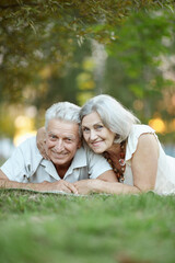 portrait of beautiful senior couple lying in park