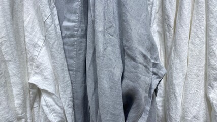 White and grey linen fabric. Rumpled clothes made of washed linen