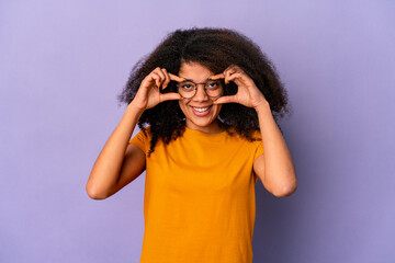 Young african american curly woman isolated on purple background excited keeping ok gesture on eye.