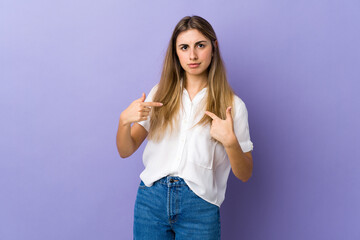 Fototapeta na wymiar Young woman over isolated purple background pointing to oneself