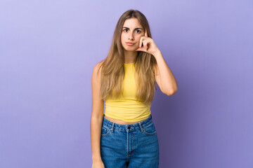 Young woman over isolated purple background thinking an idea