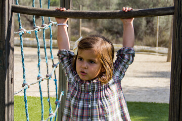 Fototapeta premium girl holding on to swing bar in park