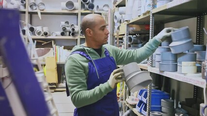 Latin american man choosing plastic pipes for plumbing work at building materials store . High quality FullHD footage