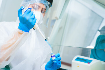 a PCR lab worker creates a vaccine against covid-19 coronavirus infection. A researcher with a dispenser in his hands makes a scientific experiment