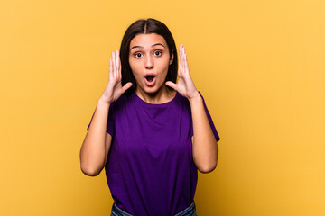 Young Indian woman isolated on yellow background surprised and shocked.
