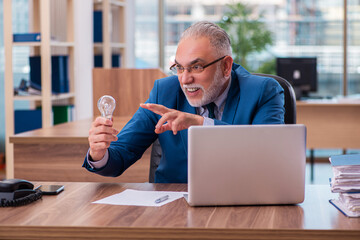 Old male employee working in the office