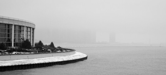city skyline covered in fog along the lakeshore