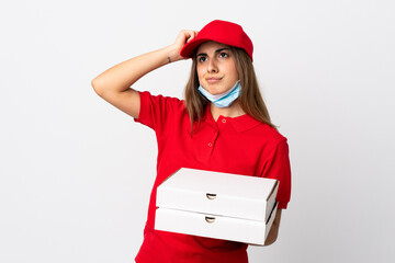 Pizza delivery woman holding a pizza and protecting from the coronavirus with a mask over isolated...