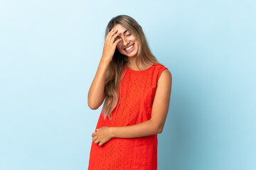 Young hispanic woman over isolated blue background laughing