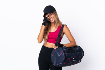 Young sport woman with sport bag over isolated white background laughing