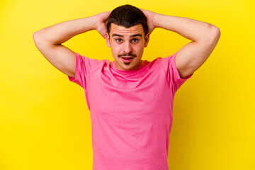 Young caucasian cool man isolated on yellow background screaming, very excited, passionate, satisfied with something.