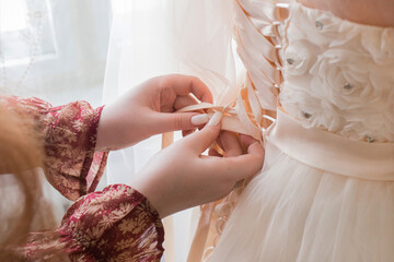 The girl's hands are tied behind the bride's wedding dress close-up