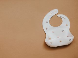 Flat lay with cute baby bib on light background. Top view, copy space