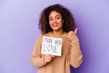 Young African American woman holding a Made with love placard isolated on purple background showing a mobile phone call gesture with fingers.